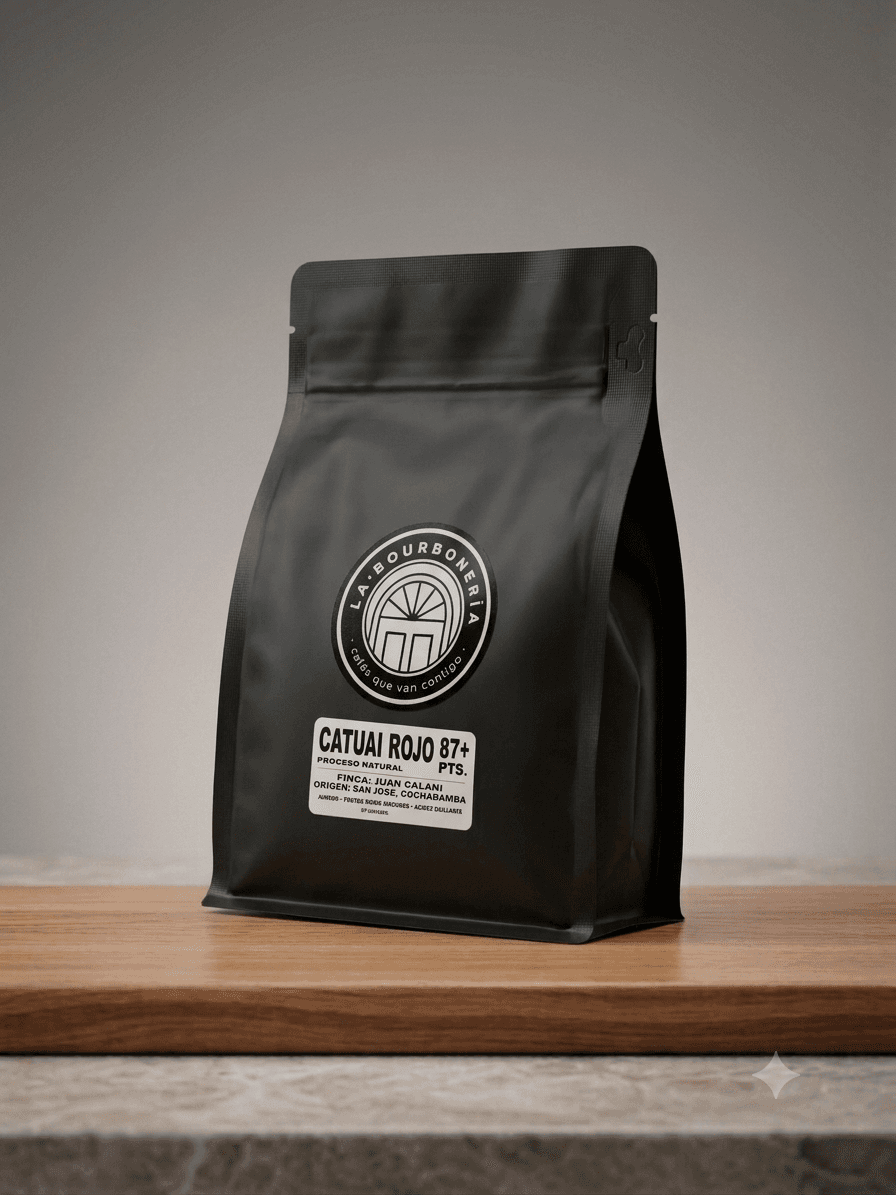 Bolsa de café negro mate marca La Bourboneria sobre una tabla de madera clara.
